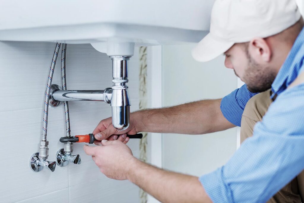 A plumber fixing the sink.