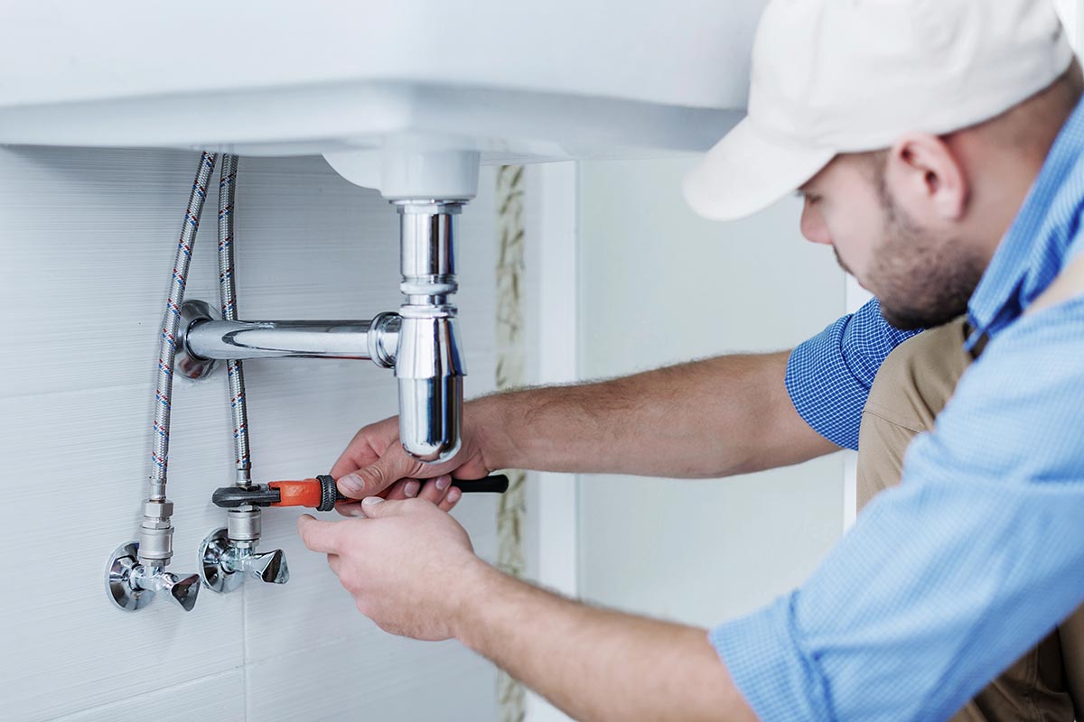 A plumber fixing the sink.